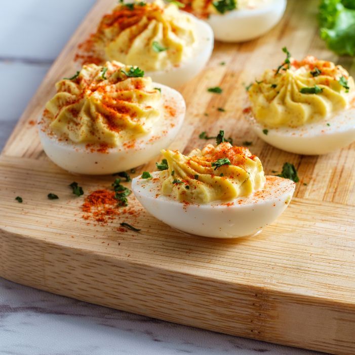 deviled eggs on a wooden cutting board